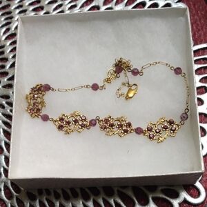 Necklace with purple beads gold metal.